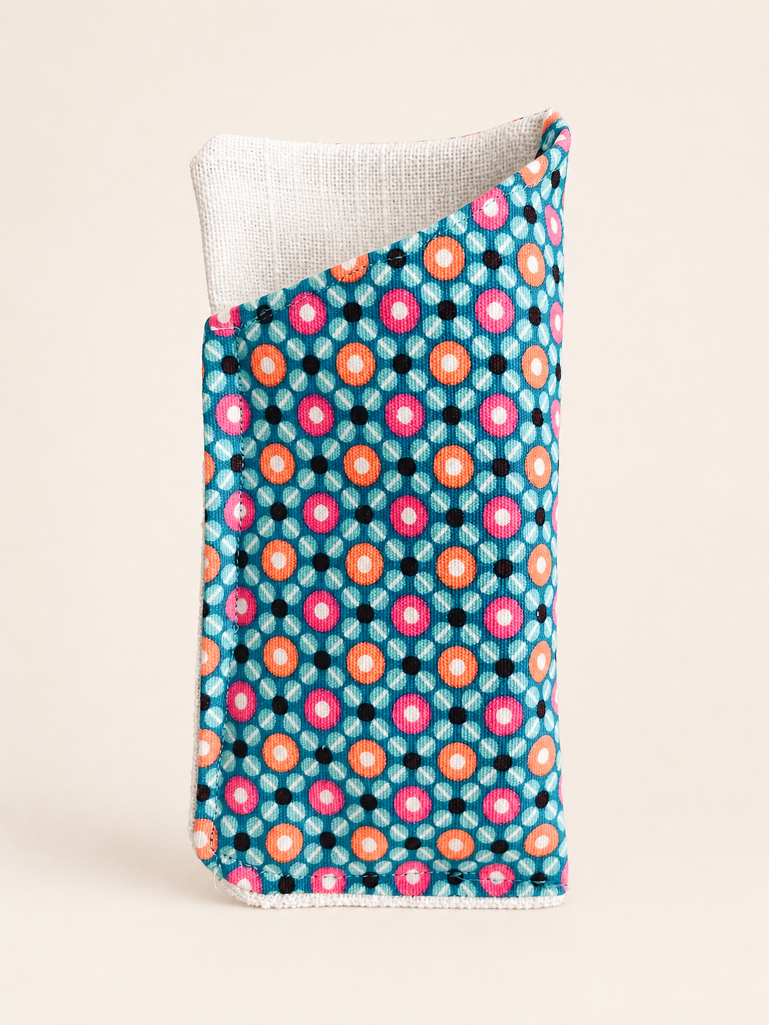 Turquoise dot eyeglass sleeve with a textured white lining on a clean studio background.